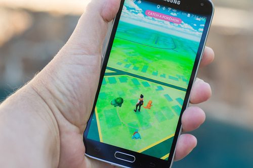 hand holding a smartphone running the app Pokémon Go