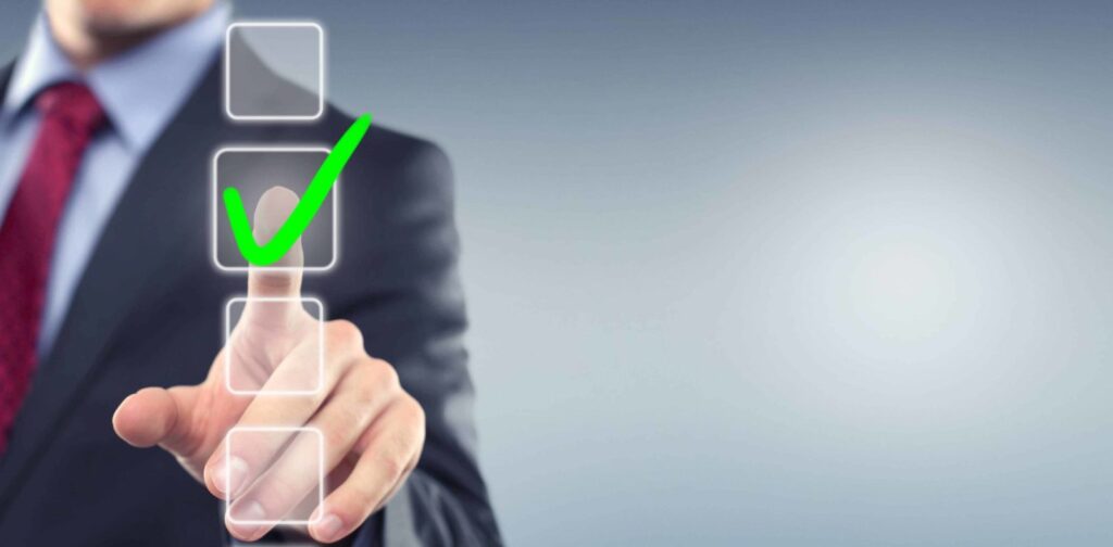 businessman pointing towards the viewer. in between him and the viewer there are floating checkboxes. he is tapping one with his finger, causing the box to fill with a green checkmark