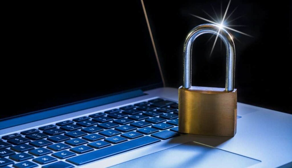 Laptop computer with padlock sitting on top of it