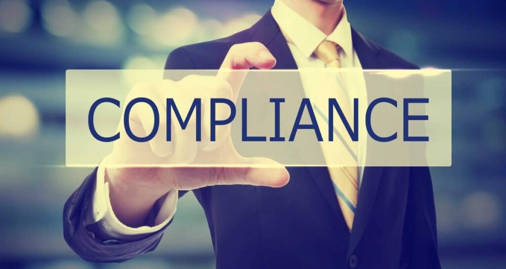 Business man holding Compliance on blurred abstract background