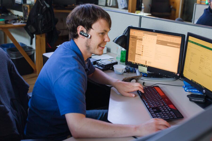 IT employee with headset working at desk